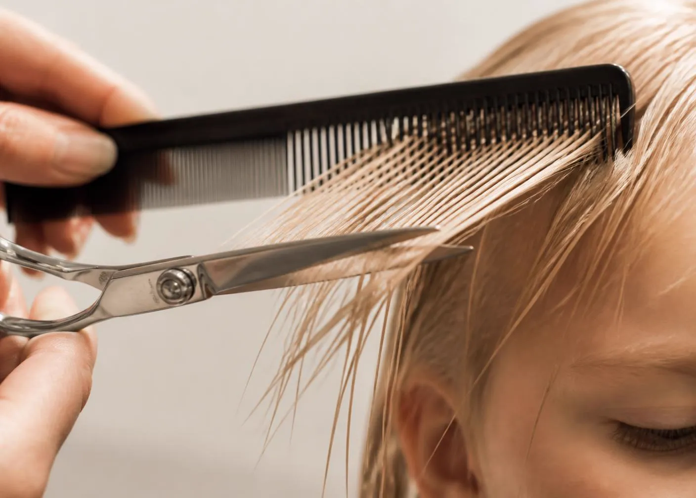 Shears and a comb mid motion during a haircut
