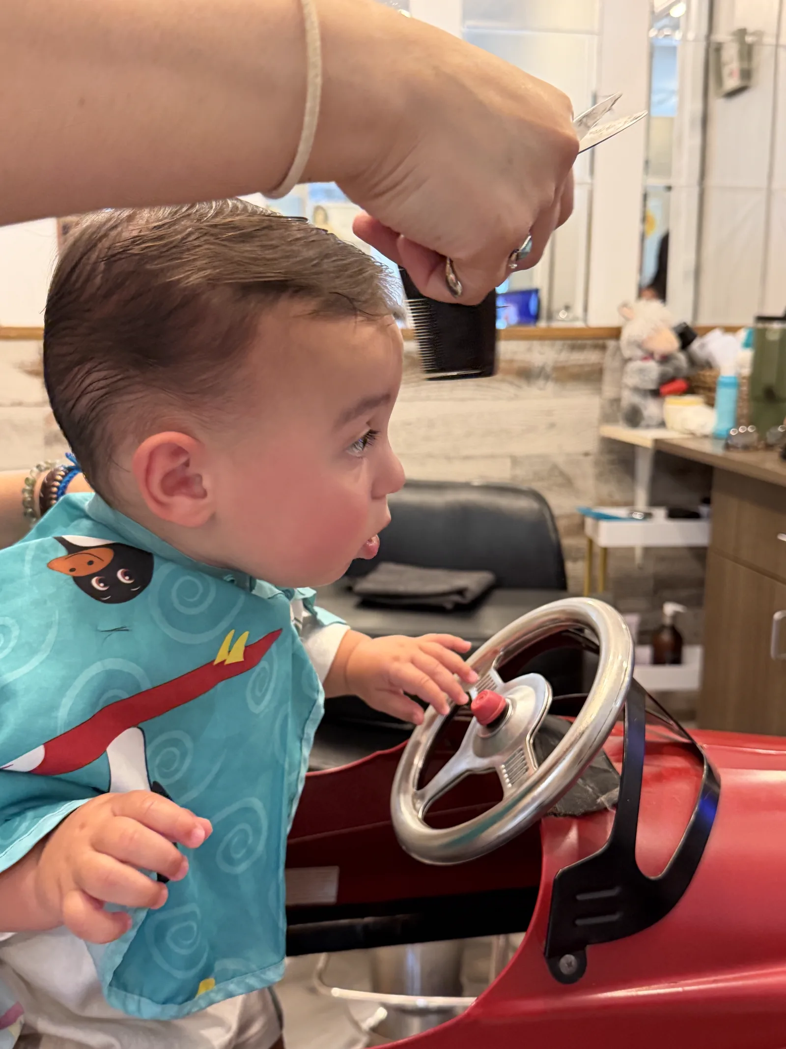 A patient stylist working at a child's pace during a haircut