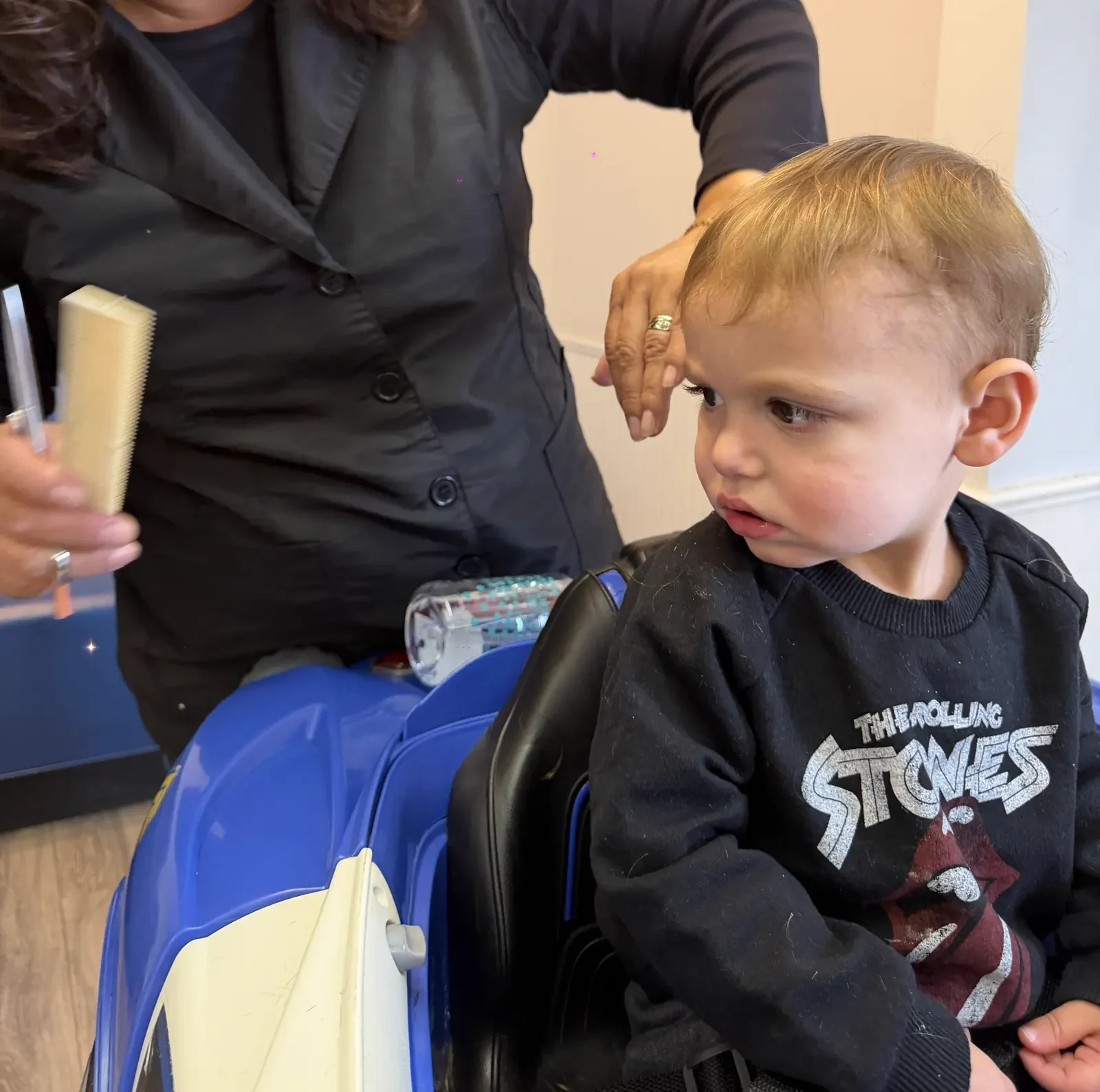 Little hands on the wheel while the haircut happens